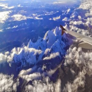 plane view of rocky mountains covered in the snow under the sunlight at daytime